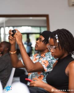 2 personnes de profil, une prenant une photo, l'autre consultant son téléphone