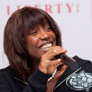 Portrait de DJ Wendy Rose de face, souriant, tenant son micro