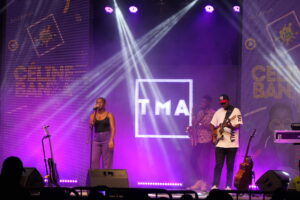 Celine Banza de face avec 2 musicines sur la scène de TMA Festival